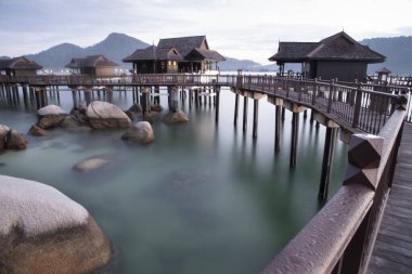 Peaceful and quiet early morning view of the boulders along the wooden houses on stilts at the Straits of Malacca 