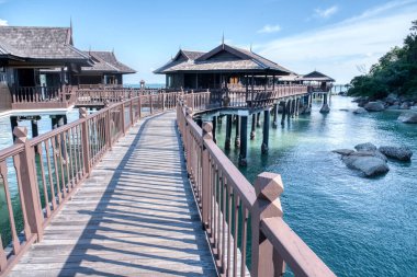 Perak,Malaysia. January 9,2022: Peaceful and quiet daytime scene of the unique architectural wooden houses or villas on stilts by the sea at Pangkor Laut Resort.