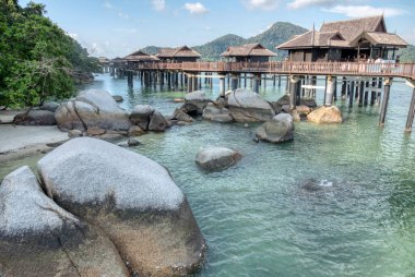 Perak,Malaysia. January 9,2022: Peaceful and quiet daytime scene of the unique architectural wooden houses or villas on stilts by the sea at Pangkor Laut Resort.