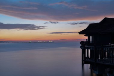 Perak,Malaysia. January 9,2022: Slow exposure shot of the night scene of the unique architectural wooden houses or villas on stilts by the sea at Pangkor Laut Resort.