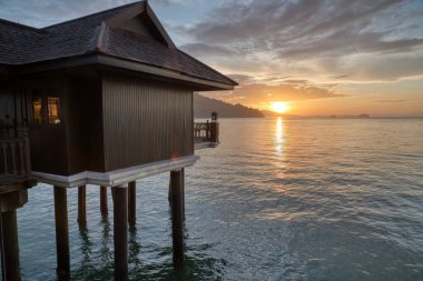 Perak,Malaysia. January 9,2022: Slow exposure shot of the night scene of the unique architectural wooden houses or villas on stilts by the sea at Pangkor Laut Resort.