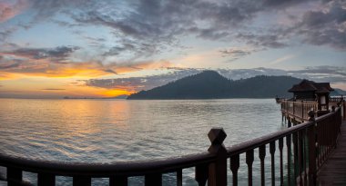 wooden bridge along the seaside during colorful sunrise 