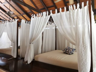 wooden bed with white mosquito netting.