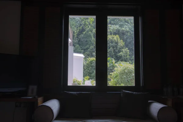 明るい窓の外をソファが見える暗室 — ストック写真