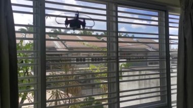 Pencereden dışarı bakan küçük oyuncak bir dron..