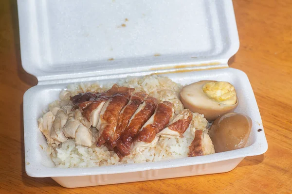 Grilled Chicken meat rice with black soy sauce egg on polystyrene box.