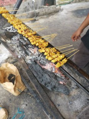 Salamura edilmiş ızgara çubukları ve ısırık büyüklüğünde tavuk eti..