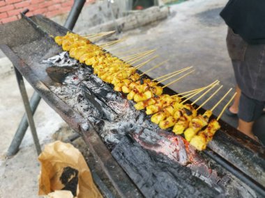 Salamura edilmiş ızgara çubukları ve ısırık büyüklüğünde tavuk eti..