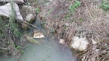 Kırsal yol boyunca akan yağmur suyu havuzu.