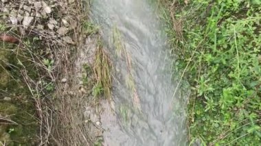 Kırsal yol boyunca akan yağmur suyu havuzu.