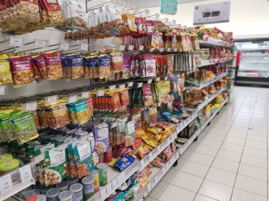 Perak, Malezya. 19 Mayıs 2022: Aeon Sri Manjung Süpermarketindeki raflarda sergilenmek ve satışa sunulmak üzere çeşitli kızartılmış veya fırında yenebilir fındık markaları paketlendi.