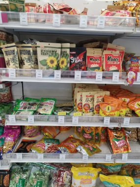 Perak, Malaysia. May 19,2022: Varieties brands of roasted or baked edible nuts are packed for display and sales on the shelves at Aeon Sri Manjung Supermarket.