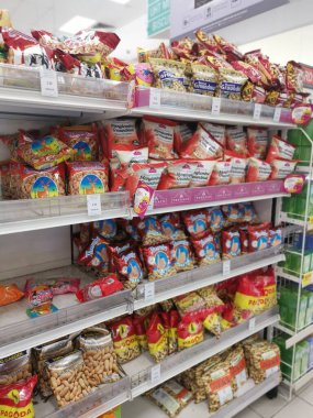 Perak, Malaysia. May 19,2022: Varieties brands of roasted or baked edible nuts are packed for display and sales on the shelves at Aeon Sri Manjung Supermarket.
