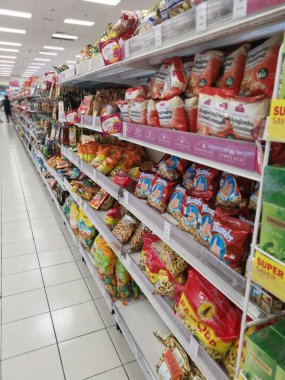 Perak, Malaysia. May 19,2022: Varieties brands of roasted or baked edible nuts are packed for display and sales on the shelves at Aeon Sri Manjung Supermarket.