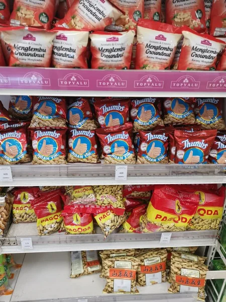 Perak, Malezya. 19 Mayıs 2022: Aeon Sri Manjung Süpermarketindeki raflarda sergilenmek ve satışa sunulmak üzere çeşitli kızartılmış veya fırında yenebilir fındık markaları paketlendi.