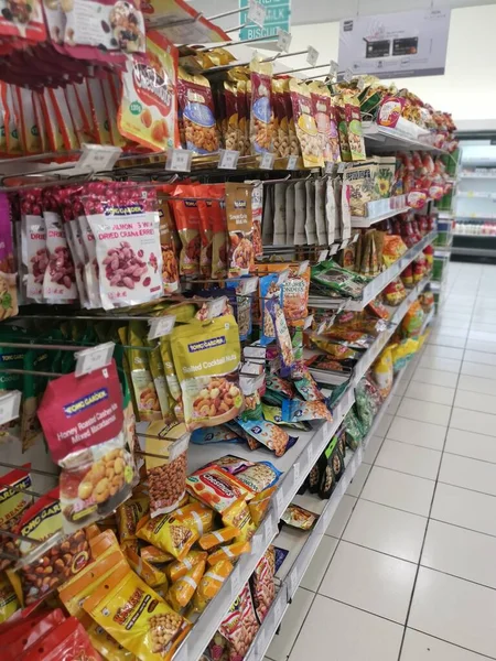 Perak, Malezya. 19 Mayıs 2022: Aeon Sri Manjung Süpermarketindeki raflarda sergilenmek ve satışa sunulmak üzere çeşitli kızartılmış veya fırında yenebilir fındık markaları paketlendi.