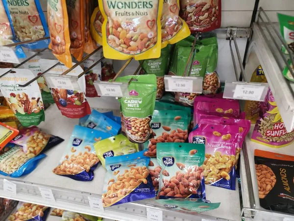 Perak, Malezya. 19 Mayıs 2022: Aeon Sri Manjung Süpermarketindeki raflarda sergilenmek ve satışa sunulmak üzere çeşitli kızartılmış veya fırında yenebilir fındık markaları paketlendi.