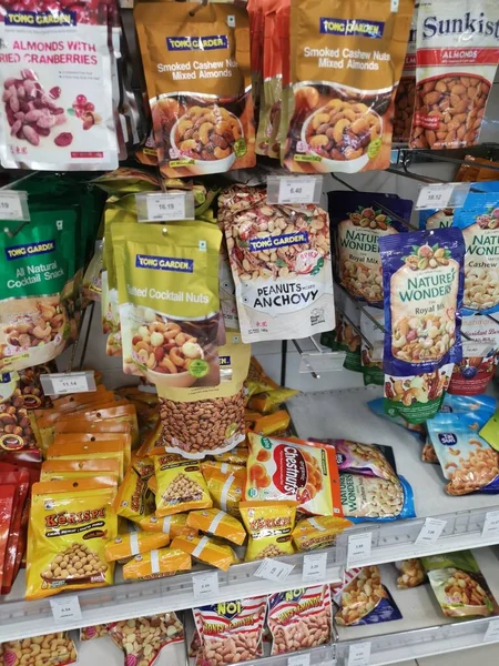 Perak, Malezya. 19 Mayıs 2022: Aeon Sri Manjung Süpermarketindeki raflarda sergilenmek ve satışa sunulmak üzere çeşitli kızartılmış veya fırında yenebilir fındık markaları paketlendi.
