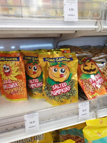 Perak, Malezya. 19 Mayıs 2022: Aeon Sri Manjung Süpermarketindeki raflarda sergilenmek ve satışa sunulmak üzere çeşitli kızartılmış veya fırında yenebilir fındık markaları paketlendi.