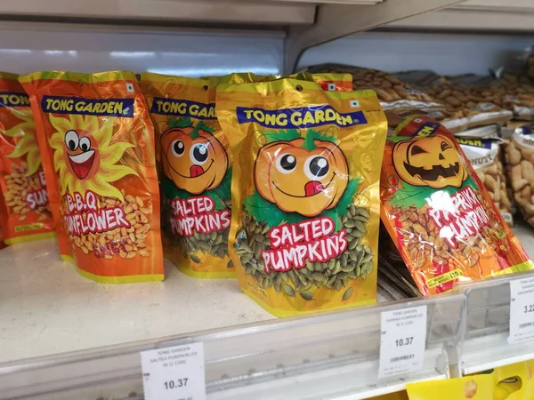 Perak, Malezya. 19 Mayıs 2022: Aeon Sri Manjung Süpermarketindeki raflarda sergilenmek ve satışa sunulmak üzere çeşitli kızartılmış veya fırında yenebilir fındık markaları paketlendi.