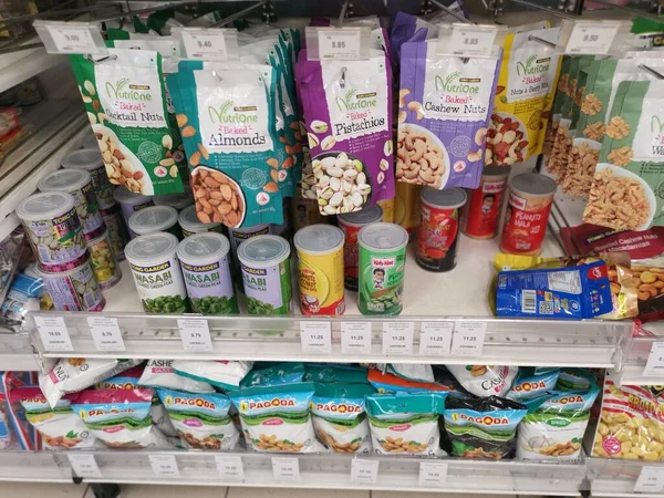 Perak, Malezya. 19 Mayıs 2022: Aeon Sri Manjung Süpermarketindeki raflarda sergilenmek ve satışa sunulmak üzere çeşitli kızartılmış veya fırında yenebilir fındık markaları paketlendi.