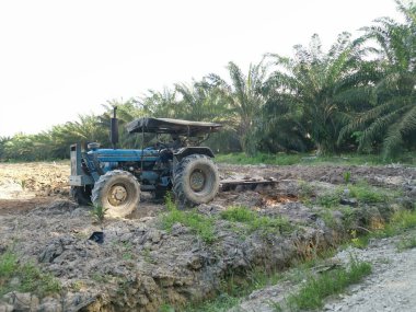 Traktörün boş araziyi sürdüğü sahne.
