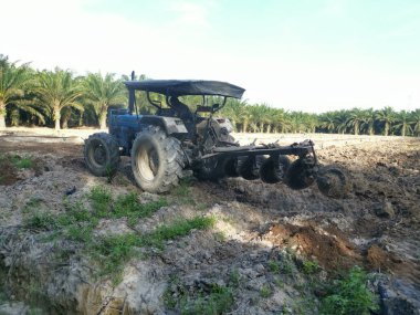 Traktörün boş araziyi sürdüğü sahne.