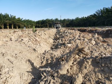 Traktörün boş araziyi sürdüğü sahne.