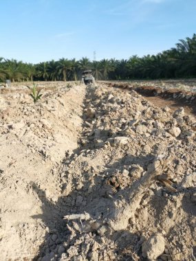 Traktörün boş araziyi sürdüğü sahne.