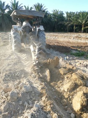 Traktörün boş araziyi sürdüğü sahne.