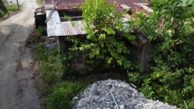 Aşınmış çinko çatılı terk edilmiş ahşap bir ev.