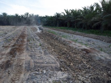 Traktörün boş araziyi sürdüğü hava sahnesi.