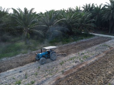 Traktörün boş araziyi sürdüğü hava sahnesi.