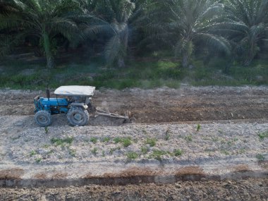 Traktörün boş araziyi sürdüğü hava sahnesi.