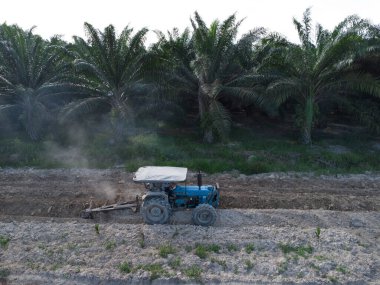 Traktörün boş araziyi sürdüğü hava sahnesi.