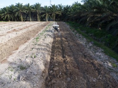 Traktörün boş araziyi sürdüğü hava sahnesi.