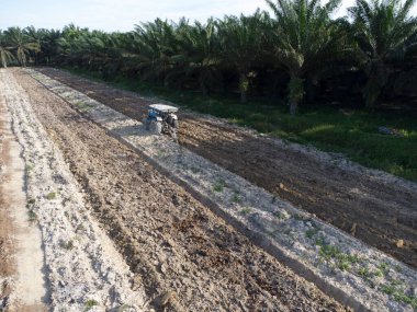 Traktörün boş araziyi sürdüğü hava sahnesi.