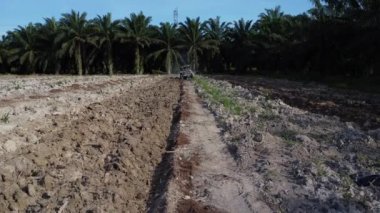 Traktörün boş araziyi sürdüğü hava sahnesi.