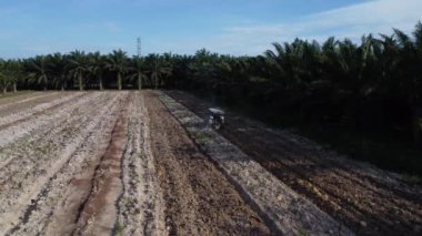 Traktörün boş araziyi sürdüğü hava sahnesi.