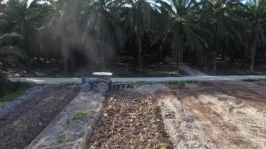 Perak, Malezya. 26 Mayıs 2022: Kampong Koh Özel Çiftliği 'nde traktörün boş tarım arazisini sürdüğü hava sahnesi.