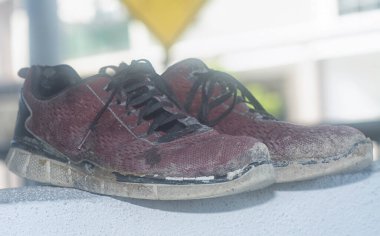 Ön verandadaki beton sütundaki yıpranmış spor ayakkabı.