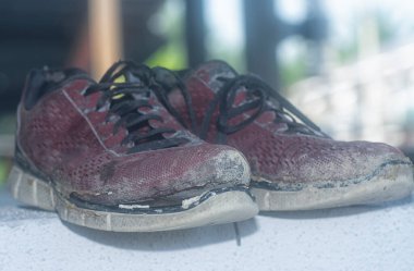 Ön verandadaki beton sütundaki yıpranmış spor ayakkabı.