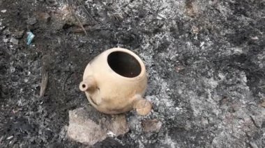 seasoned chinese herbal medicine claypot kettle at the dirty dumpster.