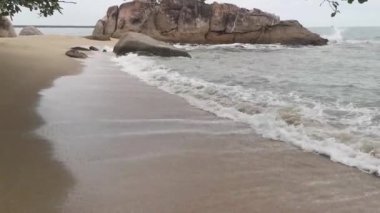 sea waves crashing onto the sandy or rocky beach.