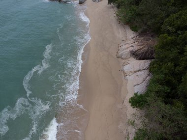 aerial scene of boulders along the sandy beach.