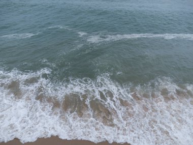 aerial scene of boulders along the sandy beach.