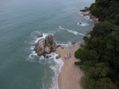 aerial scene of boulders along the sandy beach.