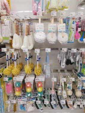 Perak,Malaysia.August 15,2022: Variety of domestic scrub brushes are hanging on shelves for display and sale at Aeon Shopping Supermarket Sri Manjung