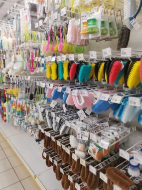 Perak,Malaysia.August 15,2022: Variety of domestic scrub brushes are hanging on shelves for display and sale at Aeon Shopping Supermarket Sri Manjung