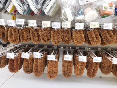 Perak,Malaysia.August 15,2022: Variety of domestic scrub brushes are hanging on shelves for display and sale at Aeon Shopping Supermarket Sri Manjung